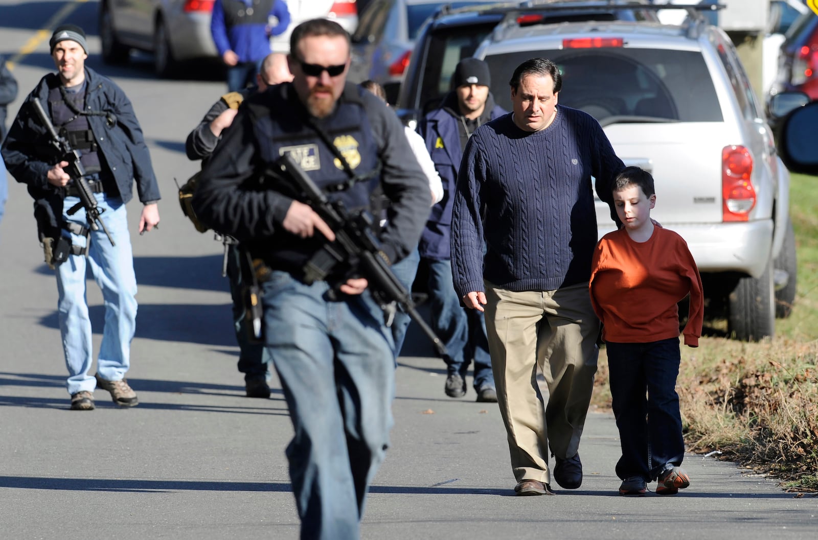 FILe — Parents leave a staging area after being reunited with their children following a shooting at the Sandy Hook Elementary School in Newtown, Conn., Friday, Dec. 14, 2012. (AP Photo/Jessica Hill, File)