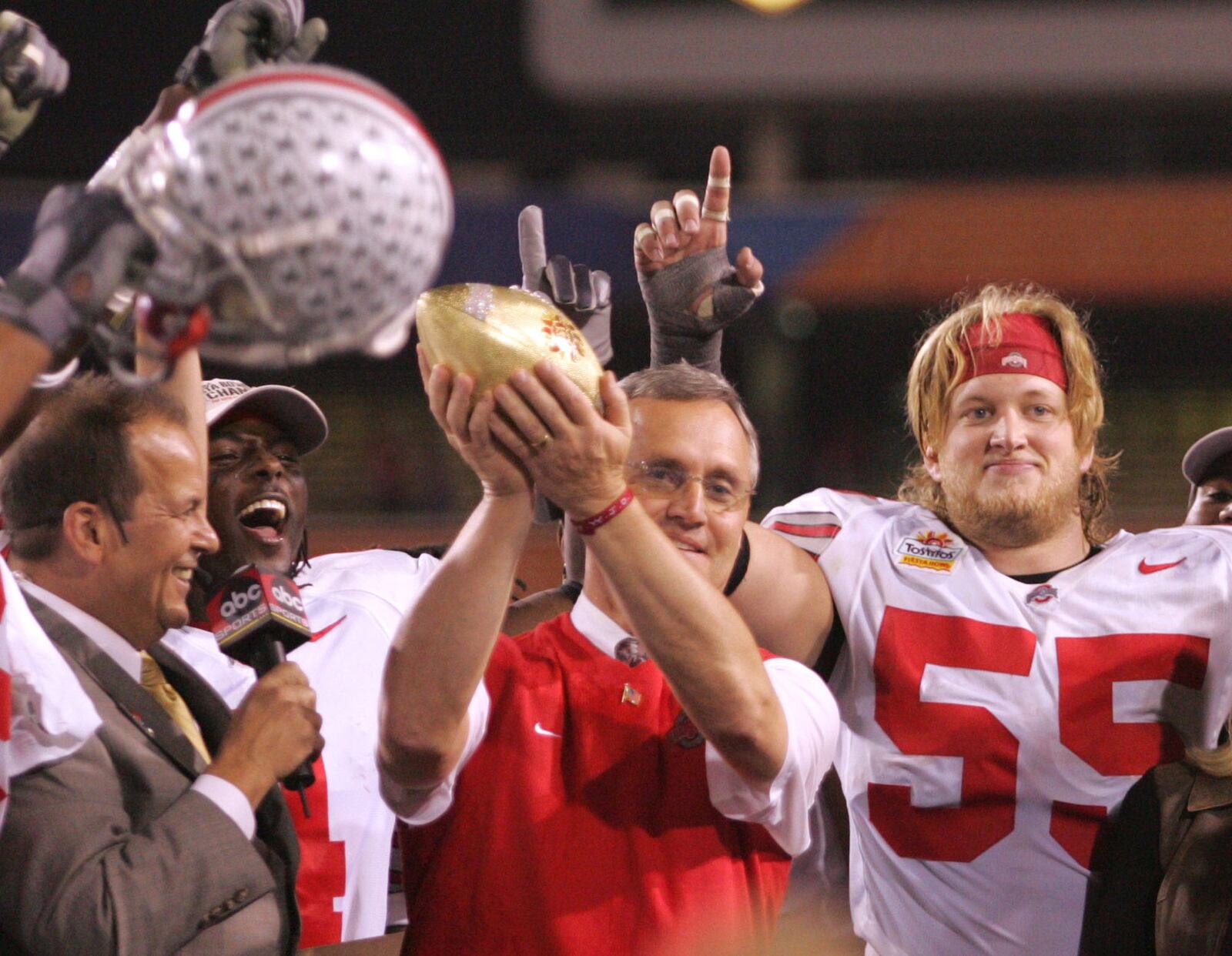 Jim Tressel, the Buckeye coach, with Nick Mangold (55) and the rest of the seniors on the stage, hoists the Fiesta Bowl trophy. Ohio State defeated Notre Dame 34-20. Dayton Daily News file