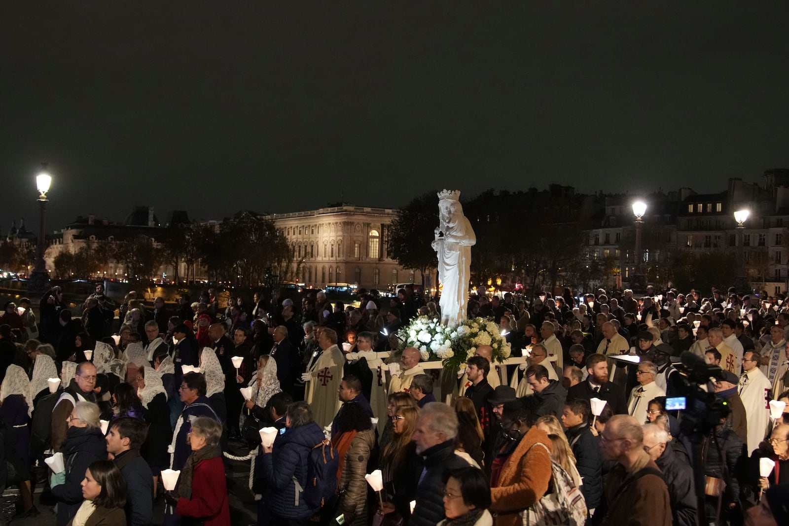 during a procession to bring the Virgin Mary statue from Saint-Germain l'Auxerrois church to Notre-Dame cathedral, Friday, Nov. 15, 2024 in Paris. (AP Photo/Christophe Ena)