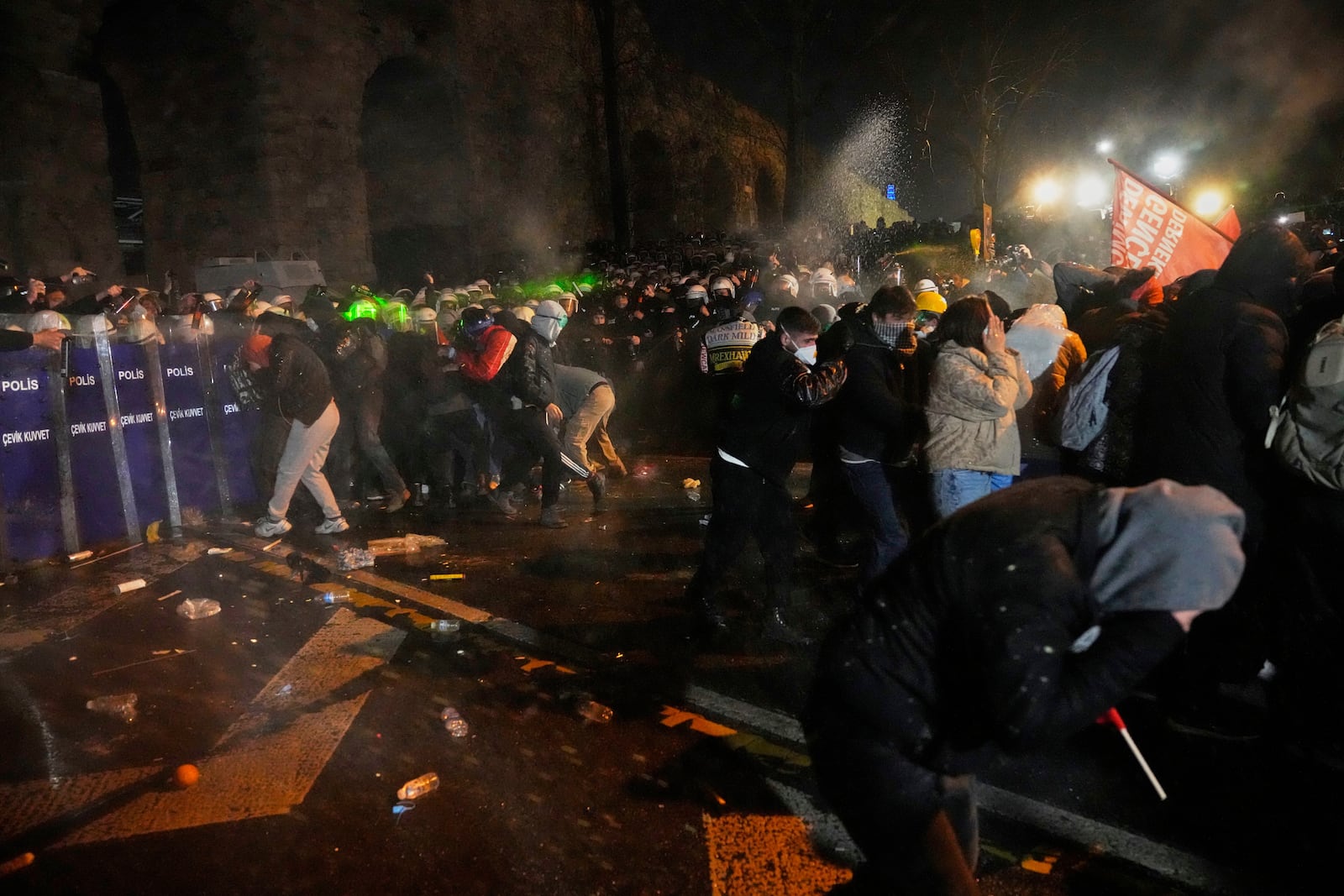 Police officers use pepper spray during clashes with people as they protest against the arrest of Istanbul's Mayor Ekrem Imamoglu, in Istanbul, Turkey, Friday, March 21, 2025. (AP Photo/Khalil Hamra)