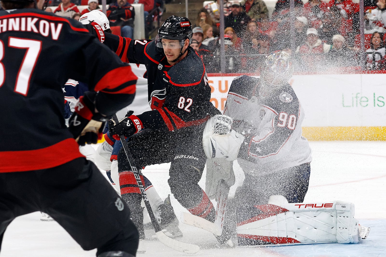 Carolina Hurricanes' Jesperi Kotkaniemi (82) battles for the puck in front of Columbus Blue Jackets goaltender Elvis Merzlikins (90) during the second period of an NHL hockey game in Raleigh, N.C., Sunday, Dec. 15, 2024. (AP Photo/Karl B DeBlaker)