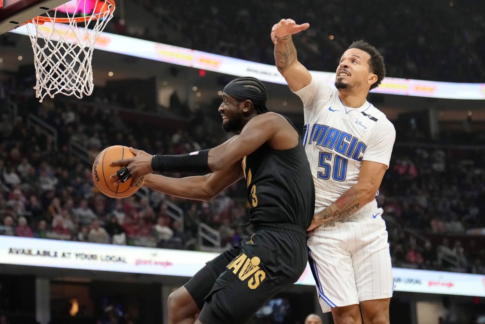 Cleveland Cavaliers guard Caris LeVert, left, goes to the basket past Orlando Magic guard Cole Anthony (50) in the first half of an NBA game, Friday, Nov. 1, 2024, in Cleveland. (AP PhotoSue Ogrocki)