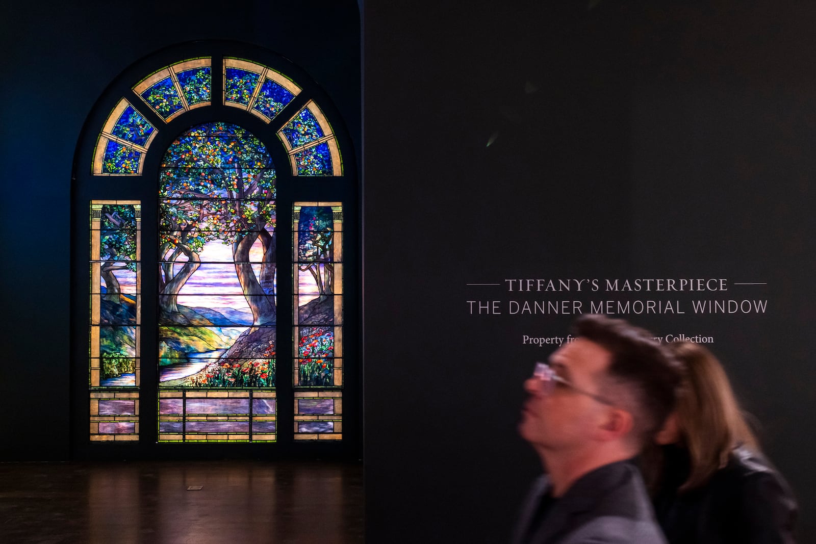 People walk near The Danner Memorial Window, by Tiffany Studios during an auction preview at Sotheby's in New York, Monday, Nov. 11, 2024. (AP Photo/Eduardo Munoz Alvarez)