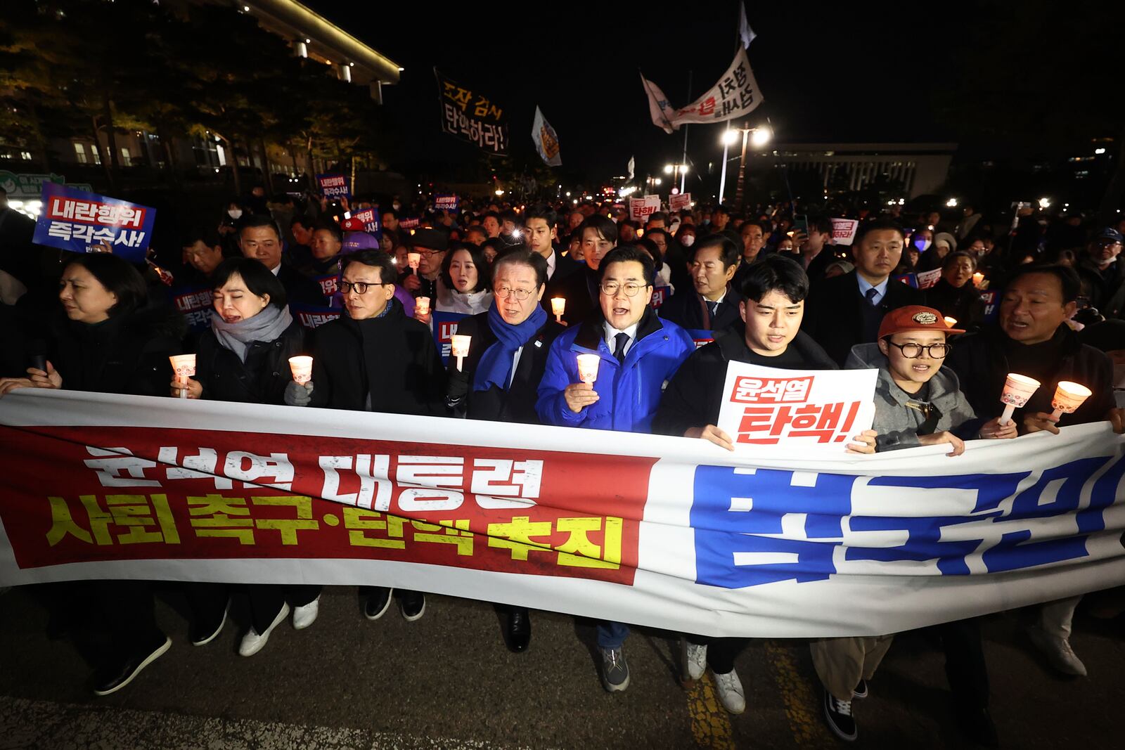 South Korea's main opposition Democratic Party leader Lee Jae-myung, center left, marches with his party members during a rally against the President Yoon Suk Yeol at the National Assembly in Seoul, South Korea, Wednesday, Dec. 4, 2024. The signs read "Yoon Suk Yeol should resign." (Ryu Hyung-seok/Yonhap via AP)