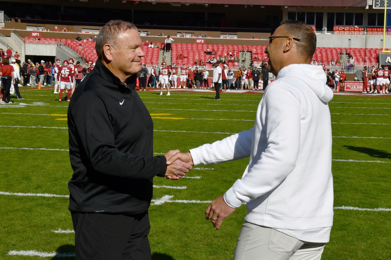 Arkansas coach Sam Pittman, left, and Texas coach Steve Sarkisian shake hands before the start of an NCAA college football game Saturday, Nov. 16, 2024, in Fayetteville, Ark. (AP Photo/Michael Woods)