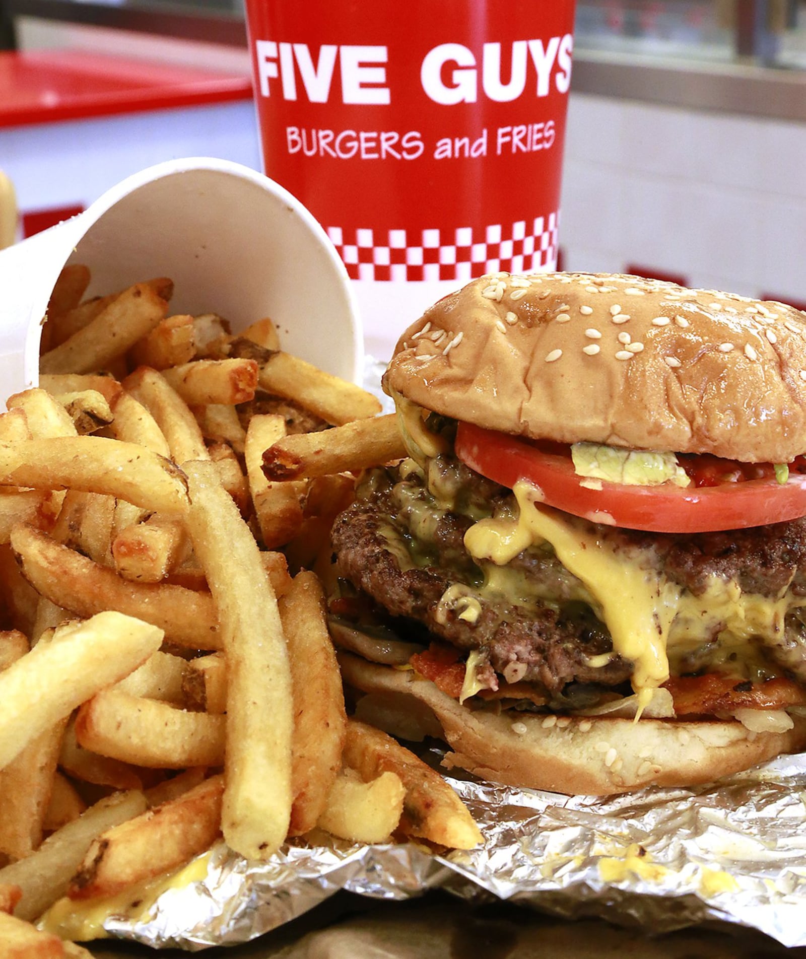 A Five Guys thiple bacon cheeseburger creation fresh off the grill. BILL LACKEY/STAFF