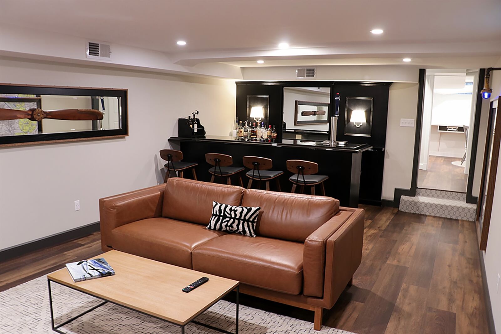 Engineered wood flooring fills the basement as a hallway leads to a recreation room, a multipurpose room and wraps around to a workshop, utility room and unfinished storage room. The recreation room has a gas fireplace with brick surround. Opposite the fireplace is a custom bar with built-in kegerator. The bar seats 4 comfortably and has additional counter space. CONTRIBUTED PHOTO BY KATHY TYLER