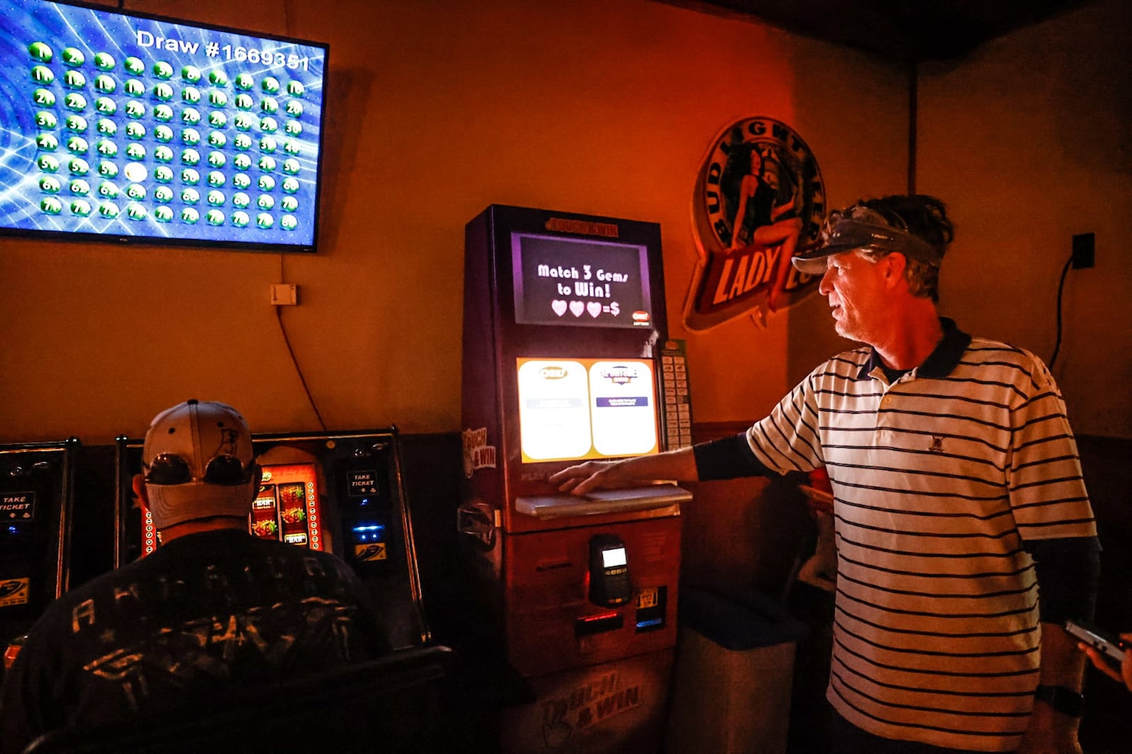 Jim Nyhan owner of Vinny's Bar & Grill, Carry-out, Lottery stands next to his lottery kiosk at the store Friday May 26, 2023. Nyhan said the kiosk has hardly been used for sports gambling, consumers seem to prefer making sports bets on their mobile phones. JIM NOELKER/STAFF