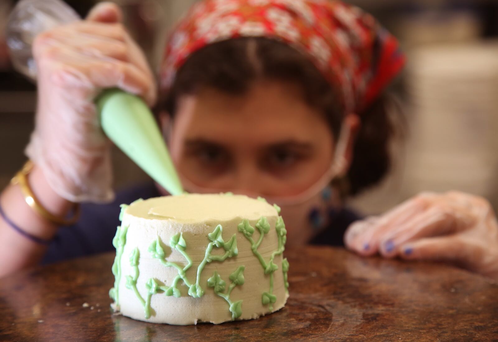 Ali Forester, a pastry designer at Purely Sweet Bakery decorates a Mini Cakes & Cream. The bakery has introduced a line of cakes, four-inches high and four-inches in diameter, meant for two people.  The business specializes in gluten free, vegan, paleo and keto products, has a variety of baked goods perfect for Valentines Day. LISA POWELL / STAFF