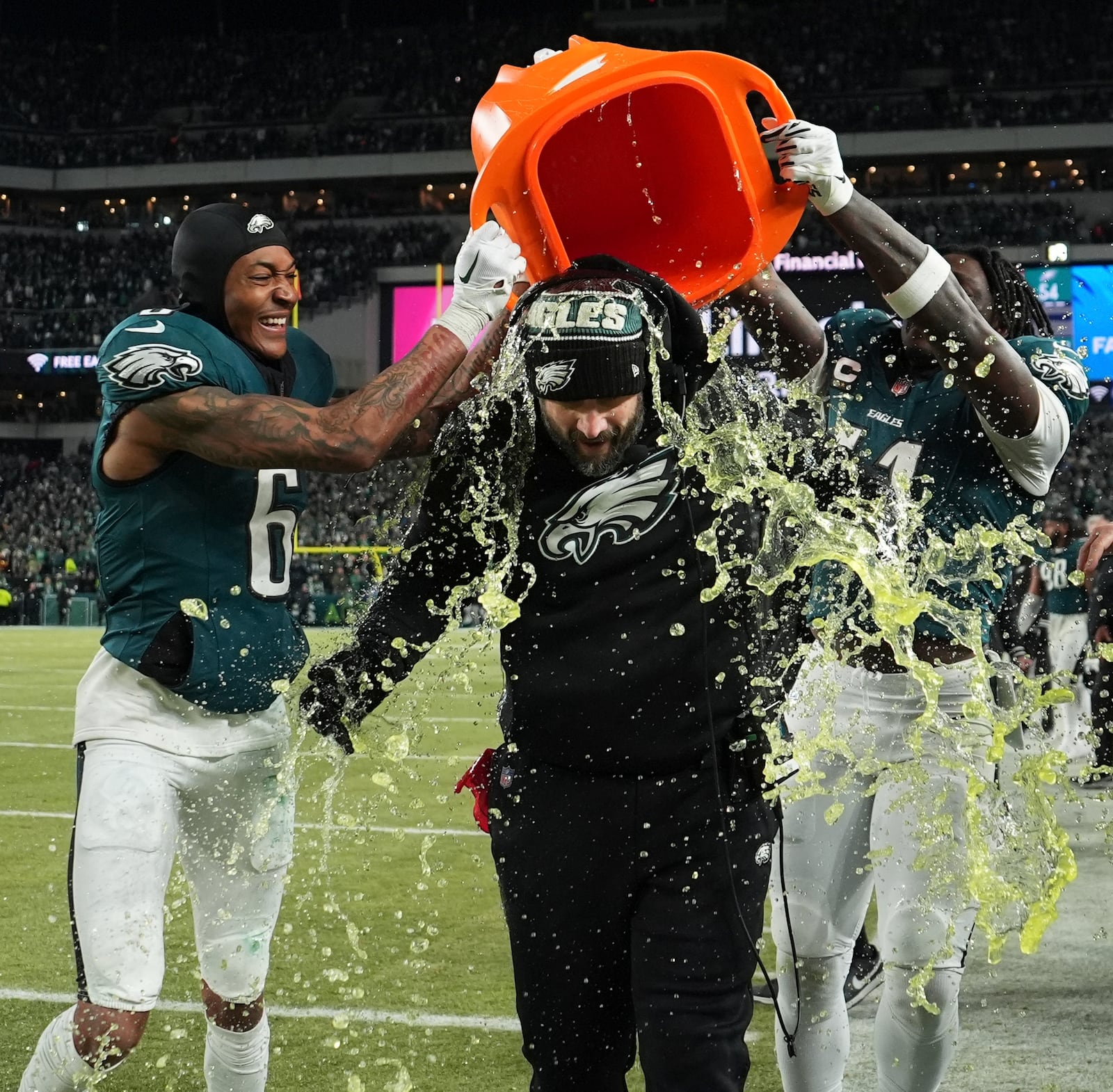 Philadelphia Eagles coach Nick Sirianni, center, is dunked by DeVonta Smith (6) and A.J. Brown (11) during the closing minutes of the second half of the NFC Championship NFL football game against the Washington Commanders, Sunday, Jan. 26, 2025, in Philadelphia. (AP Photo/Matt Slocum)