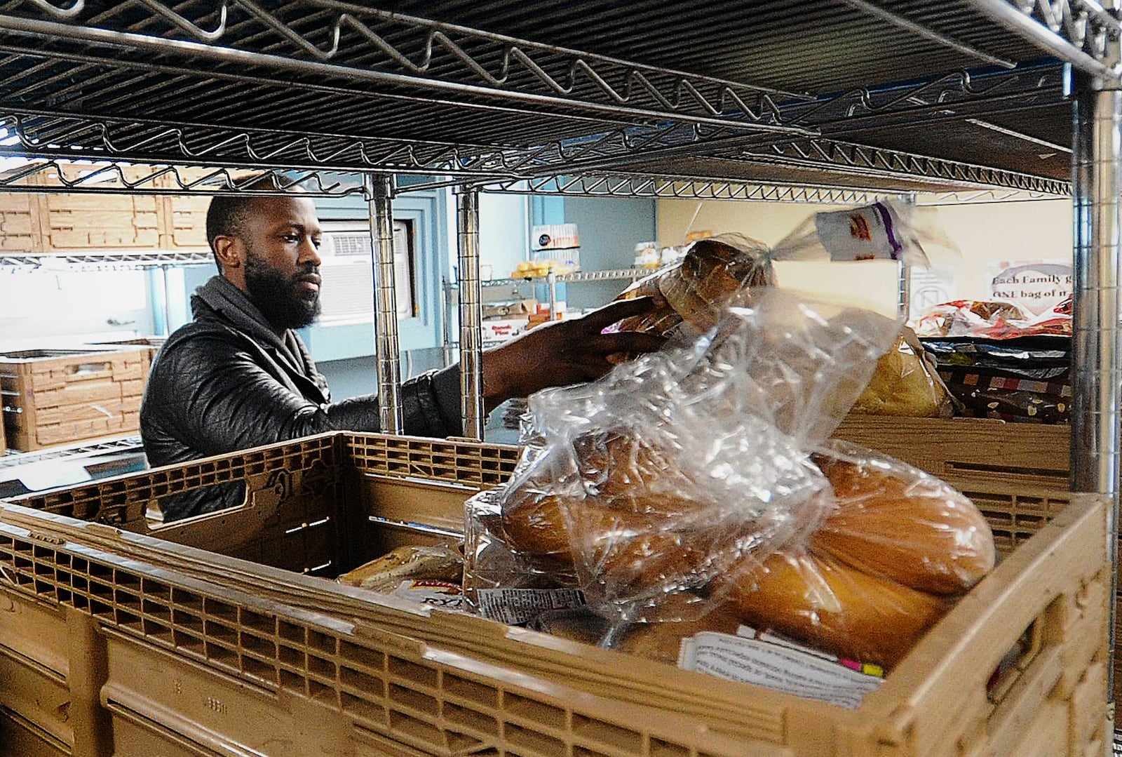 Jeremiah Bradley picks out bread, Thursday July 6, 2023 at the Catholic Social Services of the Miami Valley's Choice Food Pantry. MARSHALL GORBY\STAFF