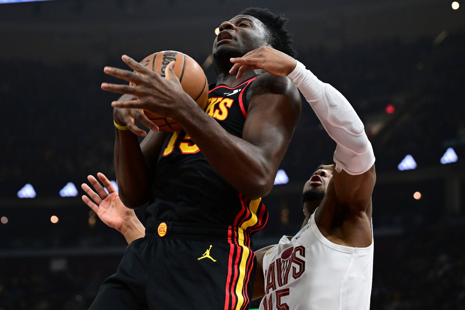 Atlanta Hawks center Clint Capela goes to the basket against Cleveland Cavaliers guard Donovan Mitchell in the first half of an NBA basketball game, Wednesday, Nov. 27, 2024, in Cleveland. (AP Photo/David Dermer)