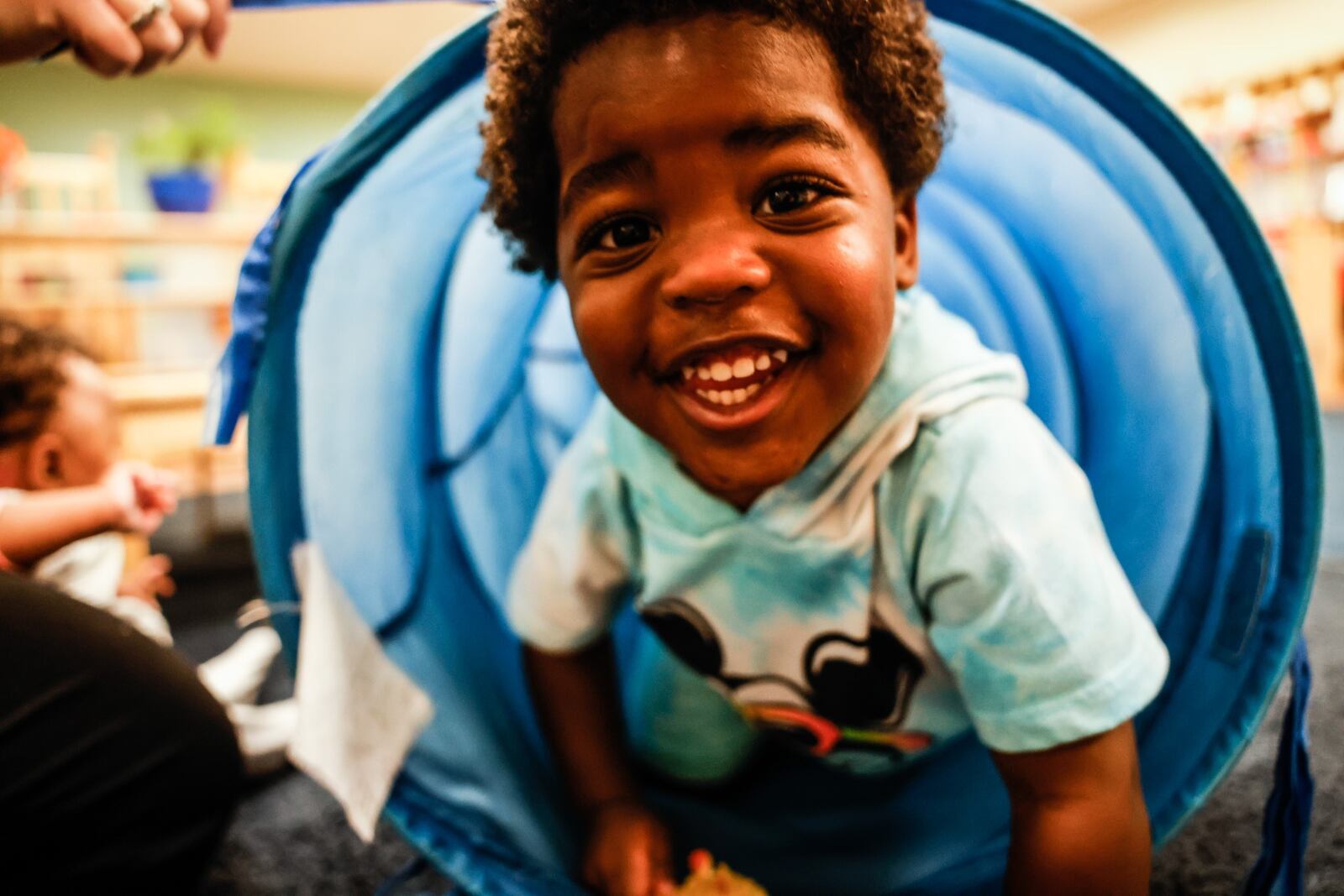 One-year-old Kylan Randall climbs through a tunnel on Tuesday, Aug. 31, 2021, at the Marilyn E. Thomas Center operated by the Miami Valley Child Development Centers on Shiloh Springs Road in Trotwood. JIM NOELKER/STAFF