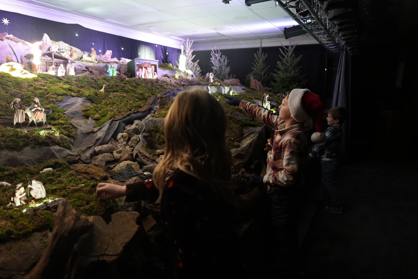 A boy points to miniature wooden figurines that are part of a Nativity scene in the community putz, a Moravian tradition that retells the story of the birth of Jesus, in Bethlehem, Pa., on Sunday, Dec. 1, 2024. (AP Photo/Luis Andres Henao)