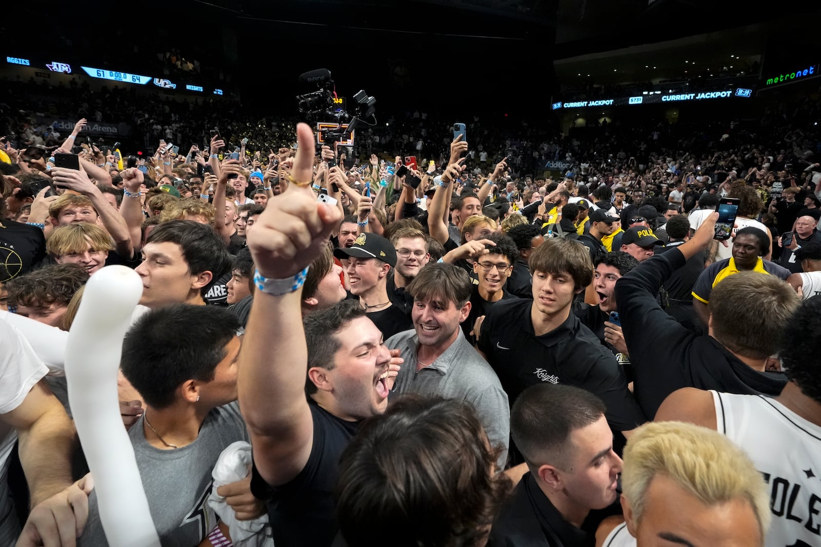 Central Florida students and fans storm the court after upsetting Texas A&M in an NCAA college basketball game, Monday, Nov. 4, 2024, in Orlando, Fla. (AP Photo/John Raoux)