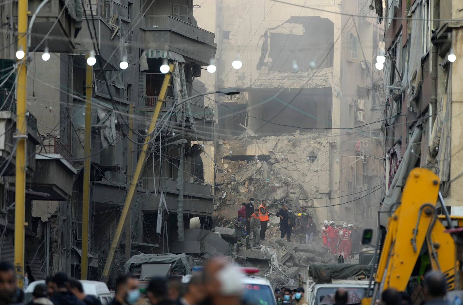 Rescue workers and people gather at the site of an Israeli airstrike that hit central Beirut, Lebanon, Saturday, Nov. 23, 2024. (AP Photo/Hassan Ammar)