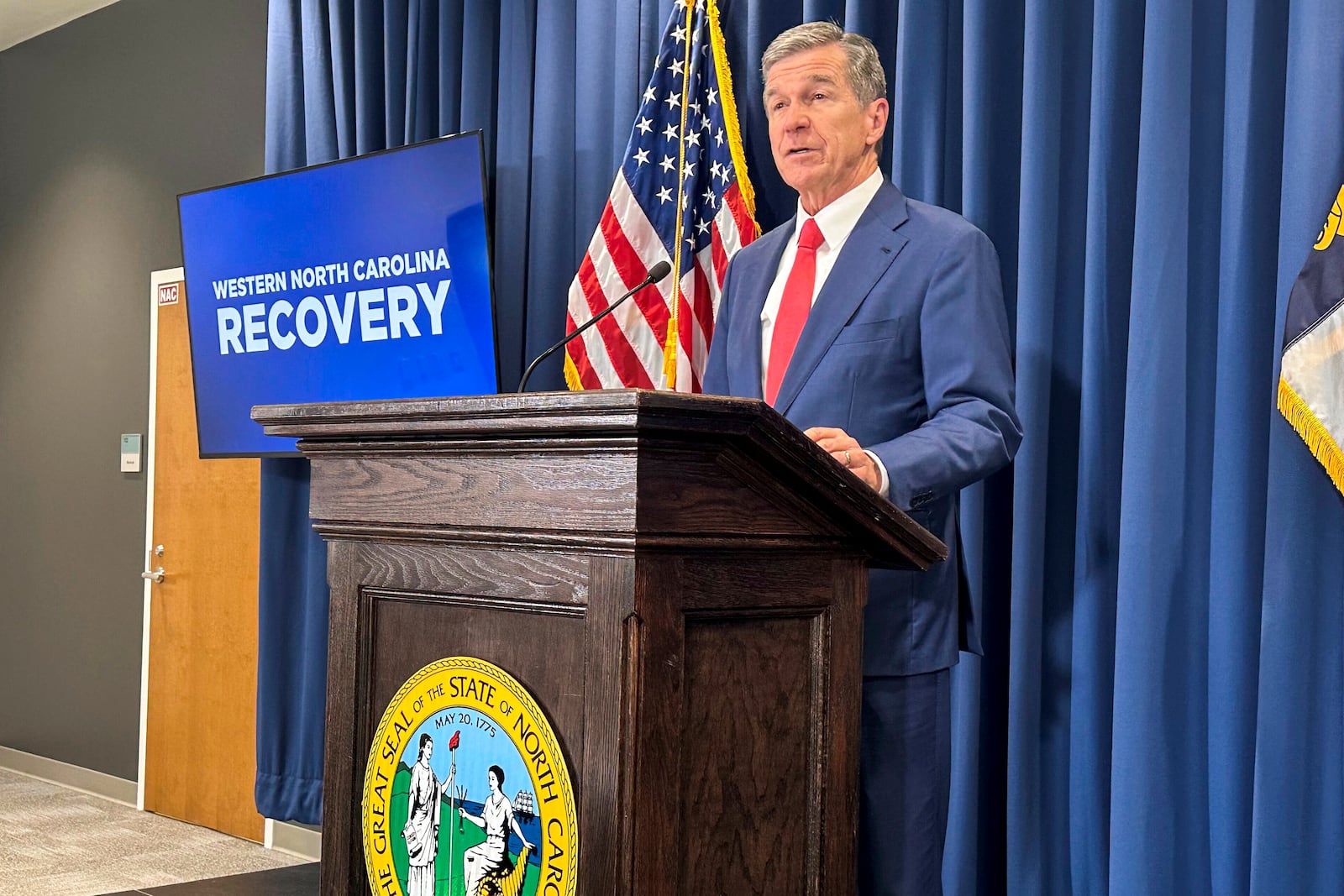 North Carolina Gov. Roy Cooper unveils a report about damages caused by Hurricane Helene and his $3.9 billion request to the General Assembly for recovery initiatives during a press conference at the Albemarle Building in Raleigh, N.C., Wednesday, Oct. 23, 2024. (AP Photo/Gary D. Robertson)