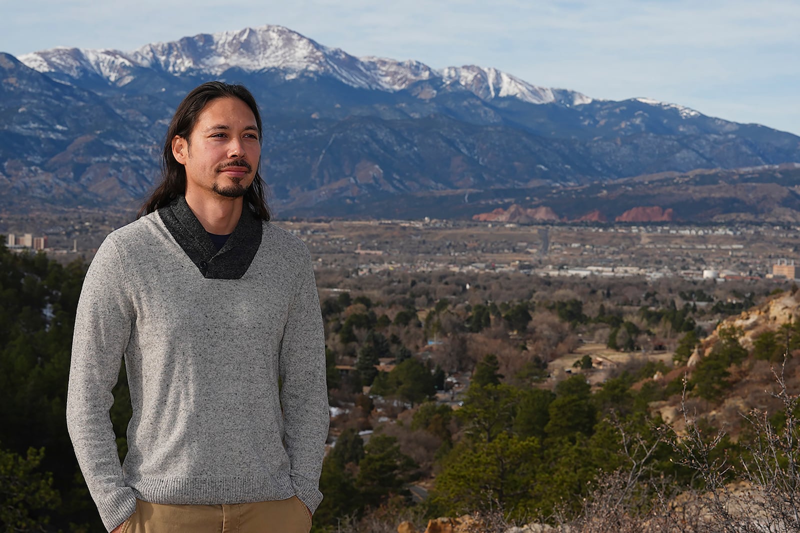 Lane Belone poses with Pikes Peak in the background on an overlook in Palmer Park, Thursday, Dec. 19, 2024, in Colorado Springs, Colo. (AP Photo/David Zalubowski)