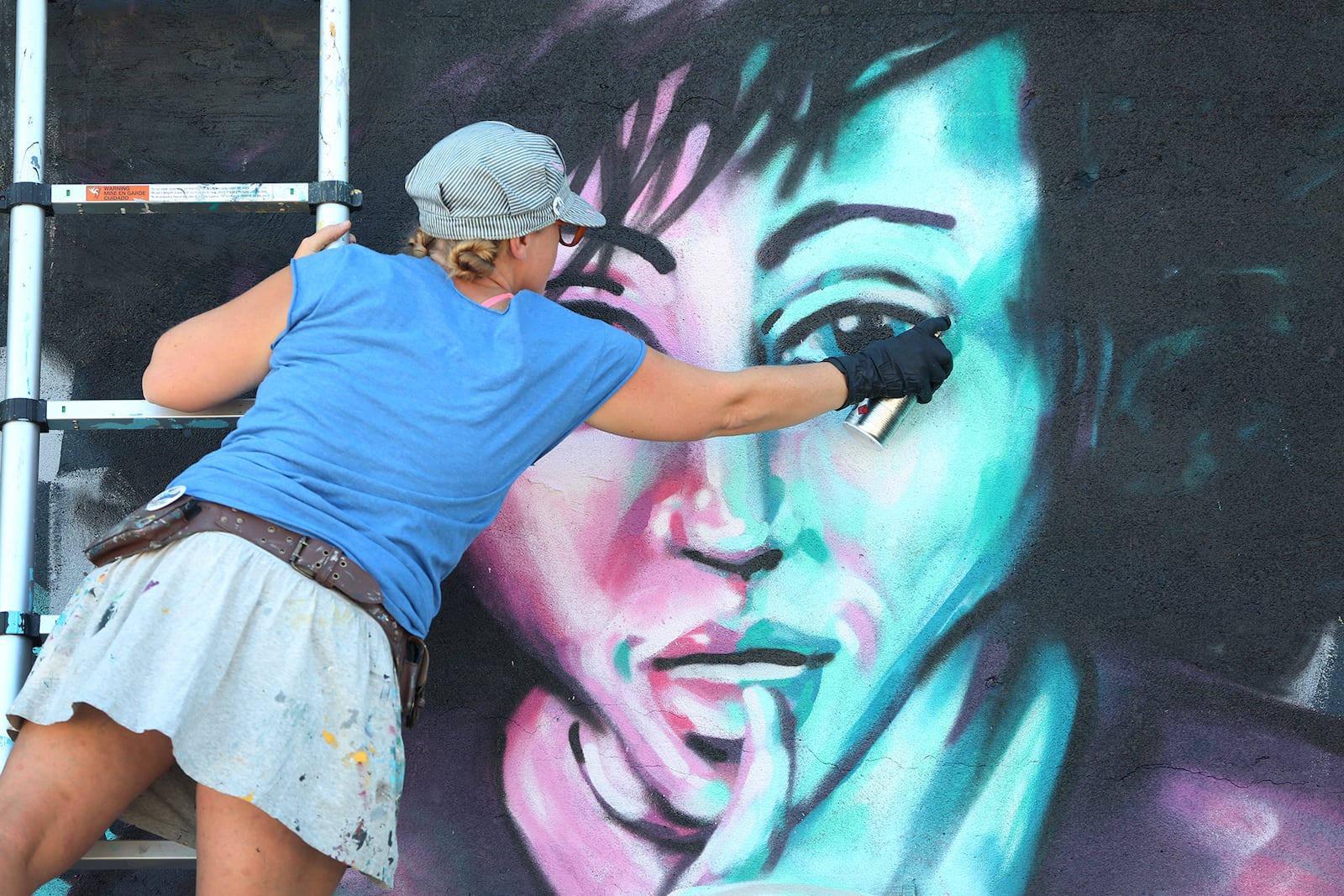 Tiffany Clark, founder of the Mural Machine, is creating a new mural at the entrance of the Oregon District in Dayton.  LISA POWELL / STAFF