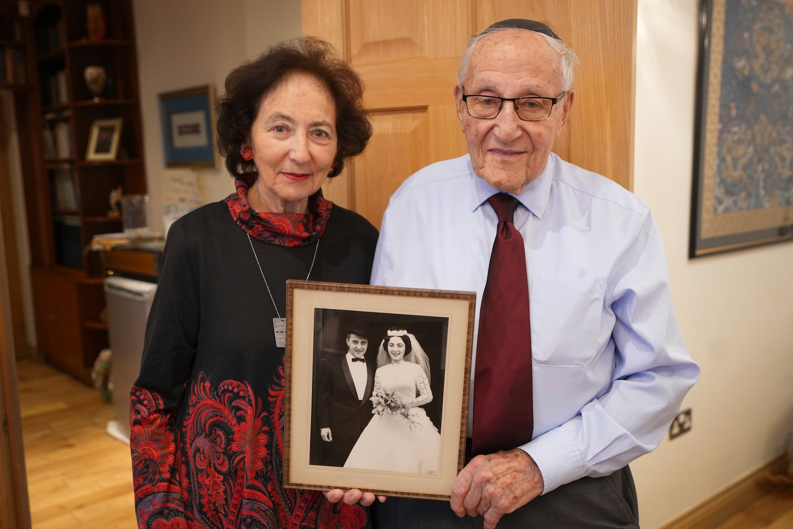 Manfred Goldberg, a Holocaust survivor with his wife Shary display their wedding photograph, as he is interviewed in London, Wednesday, Jan. 22, 2025. (AP Photo/Kirsty Wigglesworth)