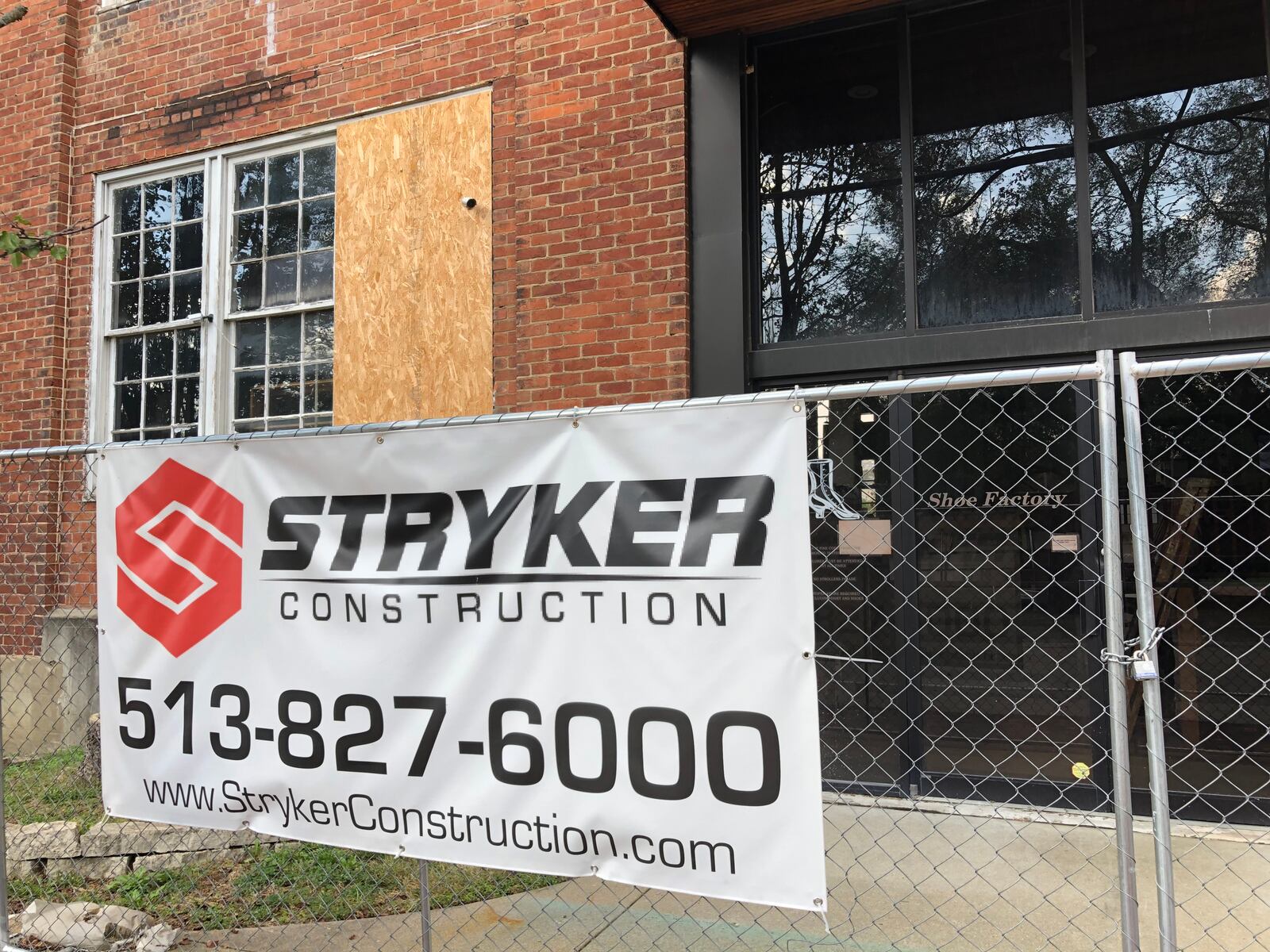 A sign for a construction company hangs from a security fence around a former shoe factory in Lebanon proposed for a  $12 million redevelopment.