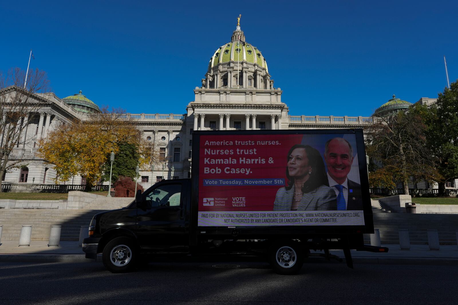 A truck displaying a banner supporting Kamala Harris in the presidential election parked in front of the Pennsylvania Capitol in Harrisburg, Pa., on Sunday, Oct. 27, 2024. (AP Photo/Luis Andres Henao)