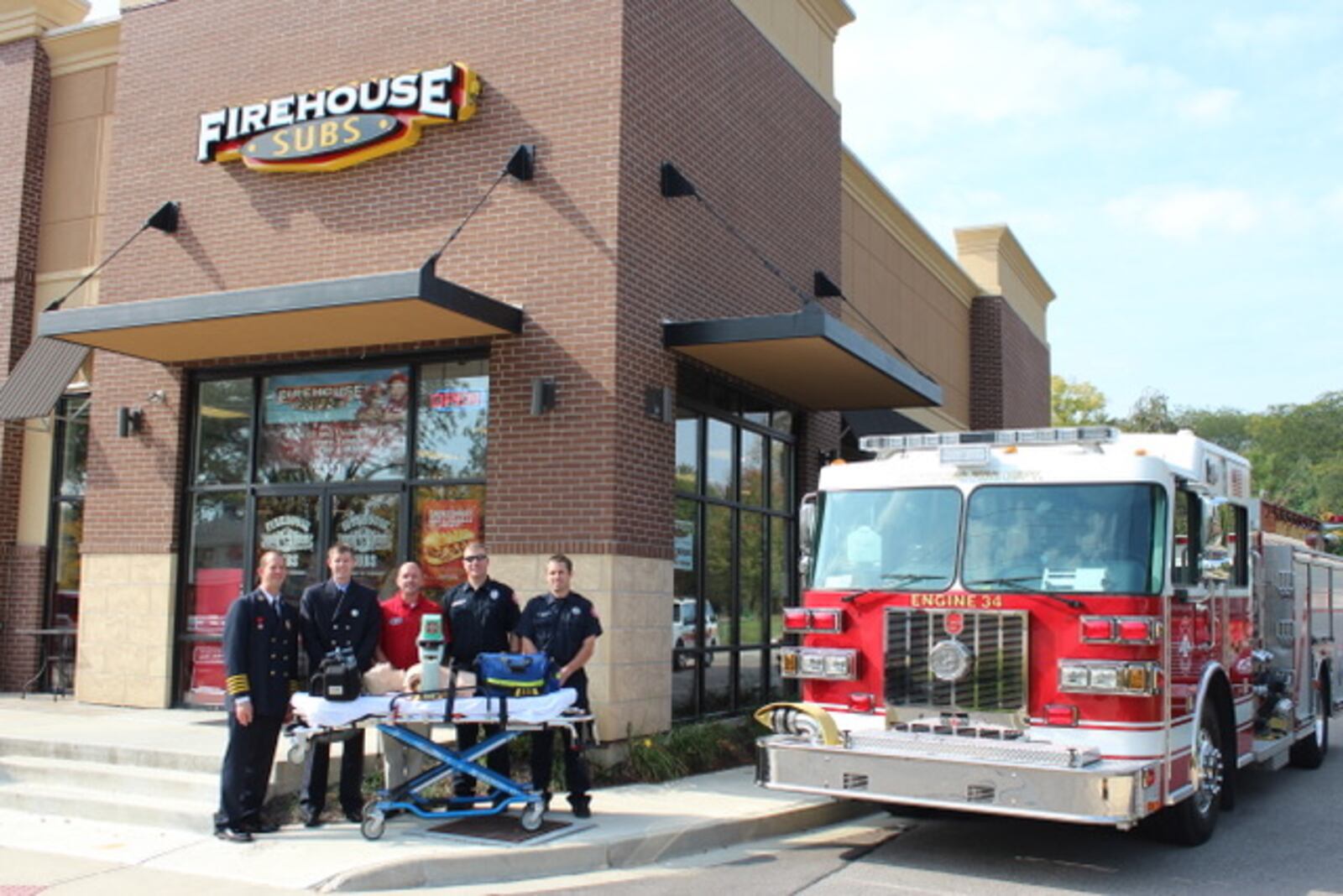 Dave Baker, center, stands with Kettering firefighters at his franchise restaurant on Far Hills Avenue in Kettering. SUBMITTED