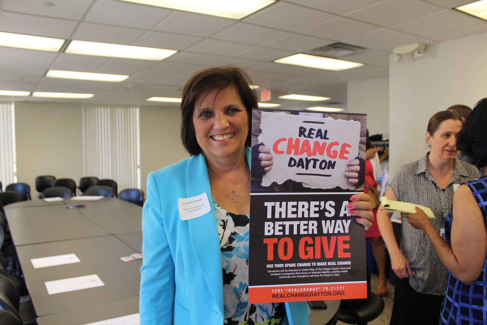 Sandy Gudorf, president of the Downtown Dayton Partnership, holds a Real Change Dayton sign. The campaign to address what officials call a panhandling explosion was launched Wednesday, June 21, 2017.