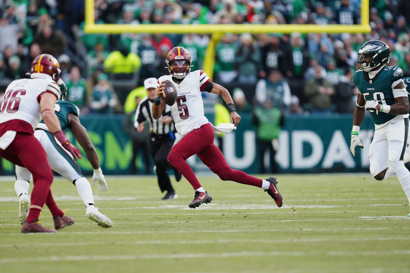 Washington Commanders quarterback Jayden Daniels (5) scrambles out of the pocket against the Philadelphia Eagles during the first half of the NFC Championship NFL football game, Sunday, Jan. 26, 2025, in Philadelphia. (AP Photo/Derik Hamilton)