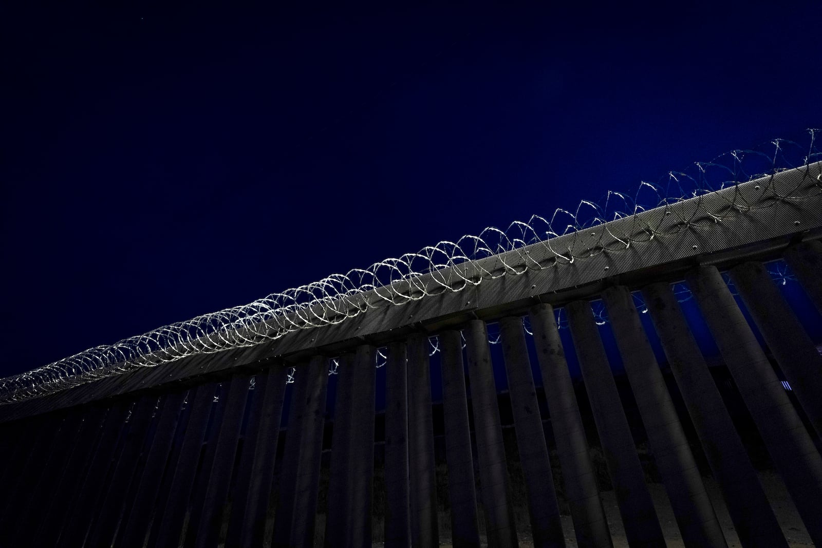 Concertina wire tops a section of a border wall separating Mexico from the United States Tuesday, Jan. 21, 2025, in San Diego. (AP Photo/Gregory Bull)