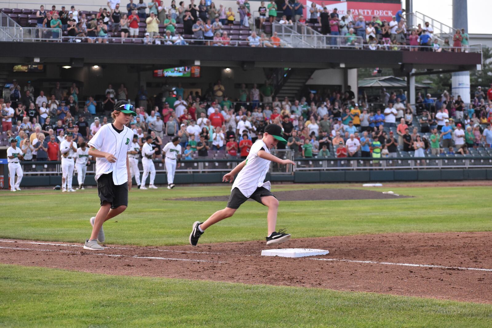 Local cancer survivor Beckett Richards, 8, runs the bases during a recent Dayton Dragons game with his big brother, Aiden, 12. SAMANTHA WILDOW\STAFF