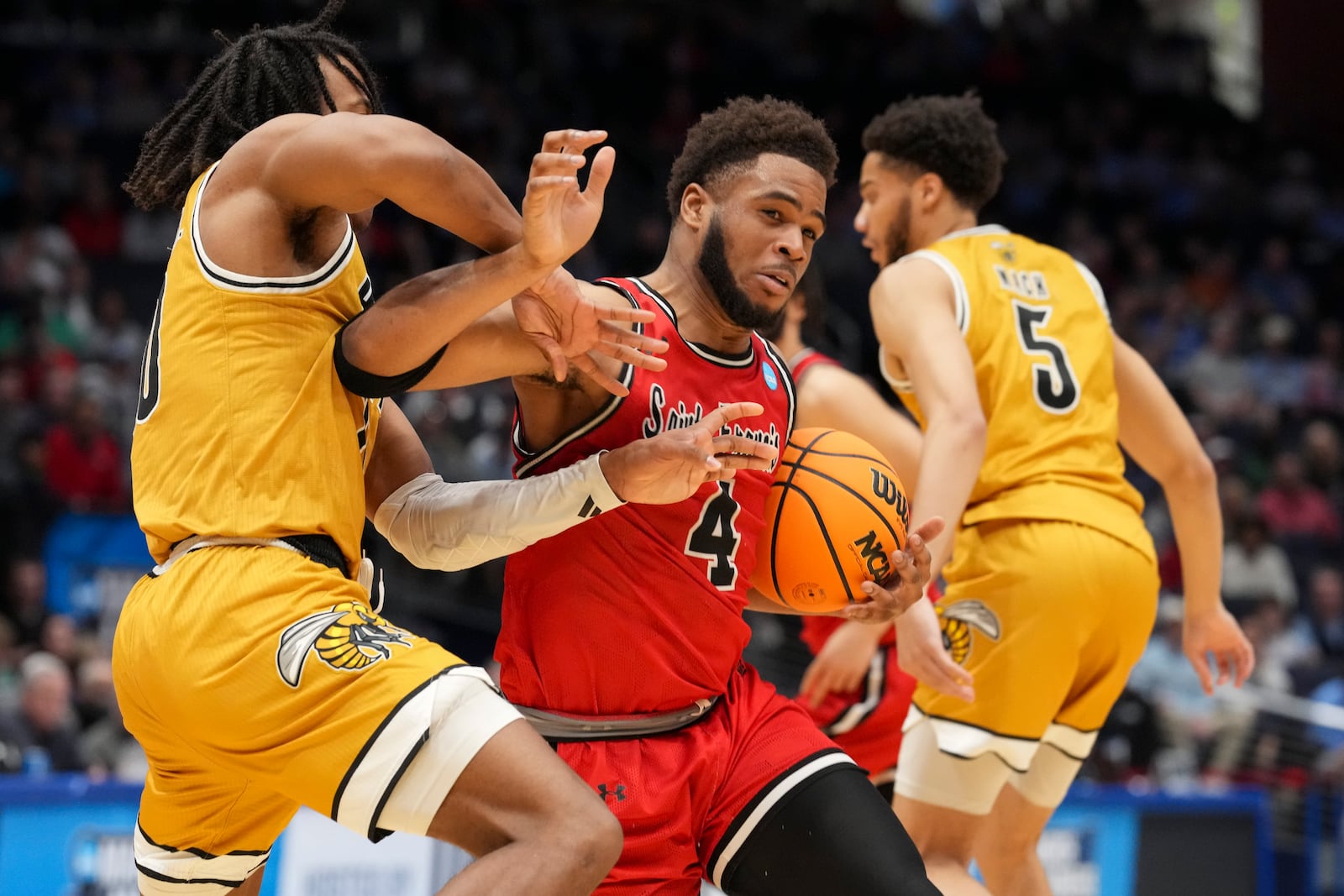 Saint Francis guard Juan Cranford Jr. (4) drives against Alabama State's TJ Madlock, left, during the first half of a First Four college basketball game in the NCAA Tournament, Tuesday, March 18, 2025, in Dayton, Ohio. (AP Photo/Jeff Dean)