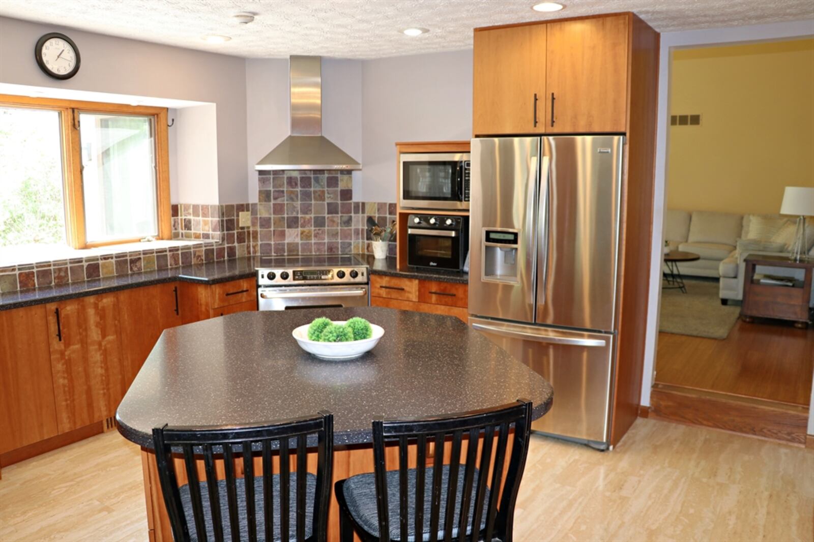 The kitchen has wood-grain contemporary cabinetry that offers two pantry closets, a coffee station, appliance garage, microwave shelf and island storage options. 