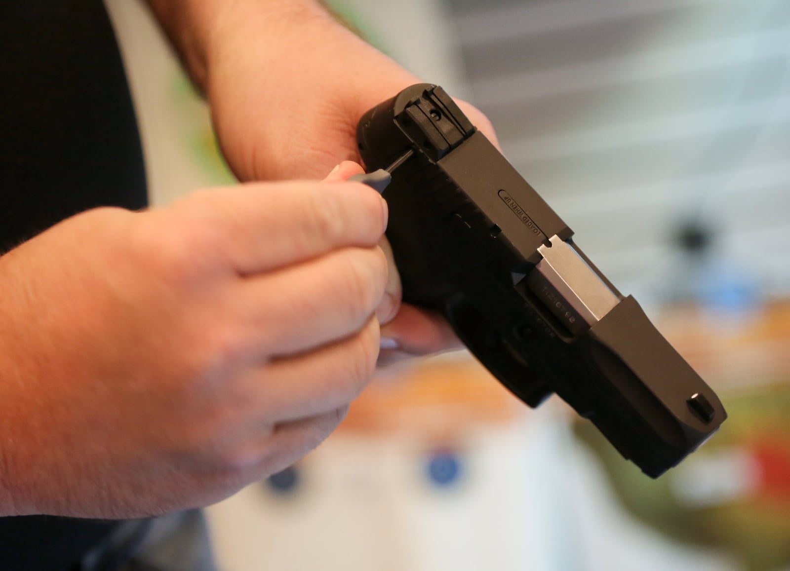 Mike Reed, owner of Right 2 Arm Firearms demonstrates the built in keyed gun lock on a Taurus PT111 handgun at their Liberty Twp. store, Friday, July 1, 2016. GREG LYNCH / STAFF