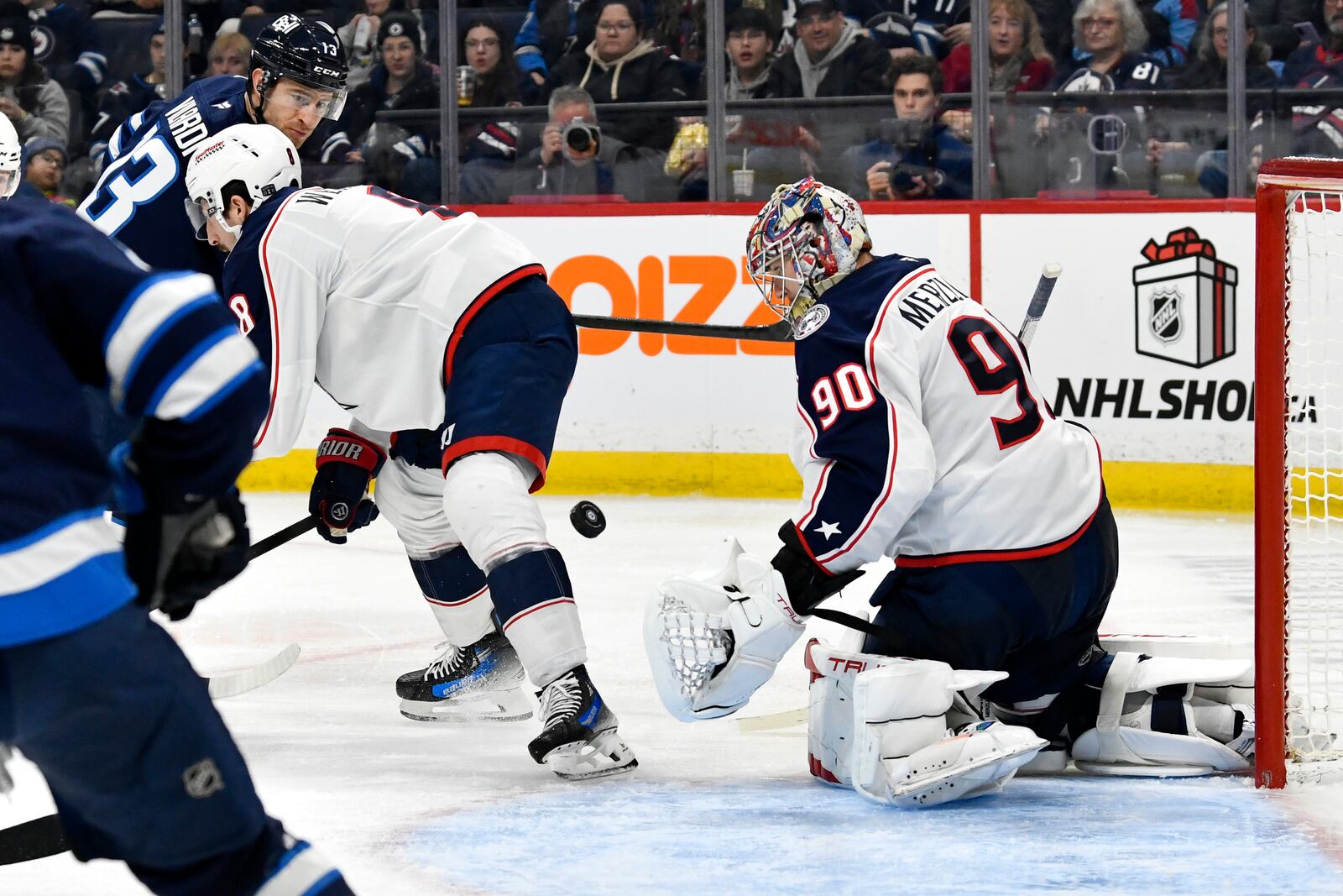 Columbus Blue Jackets' goaltender Elvis Merzlikins (90) makes a save on Winnipeg Jets' Gabriel Vilardi (13) during the second period of an NHL hockey game in Winnipeg, Canada Sunday, Dec. 8, 2024. (Fred Greenslade/The Canadian Press via AP)