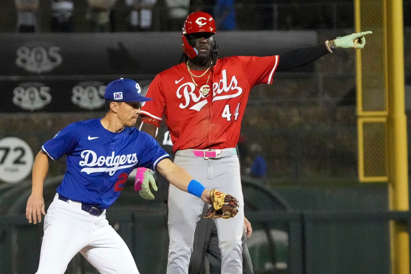 Cincinnati Reds' Elly De La Cruz (44) gestures behind Los Angeles Dodgers Tommy Edman after hitting a double during the sixth inning of a spring training baseball game, Tuesday, March. 4, 2025, in Phoenix. (AP Photo/Darryl Webb)