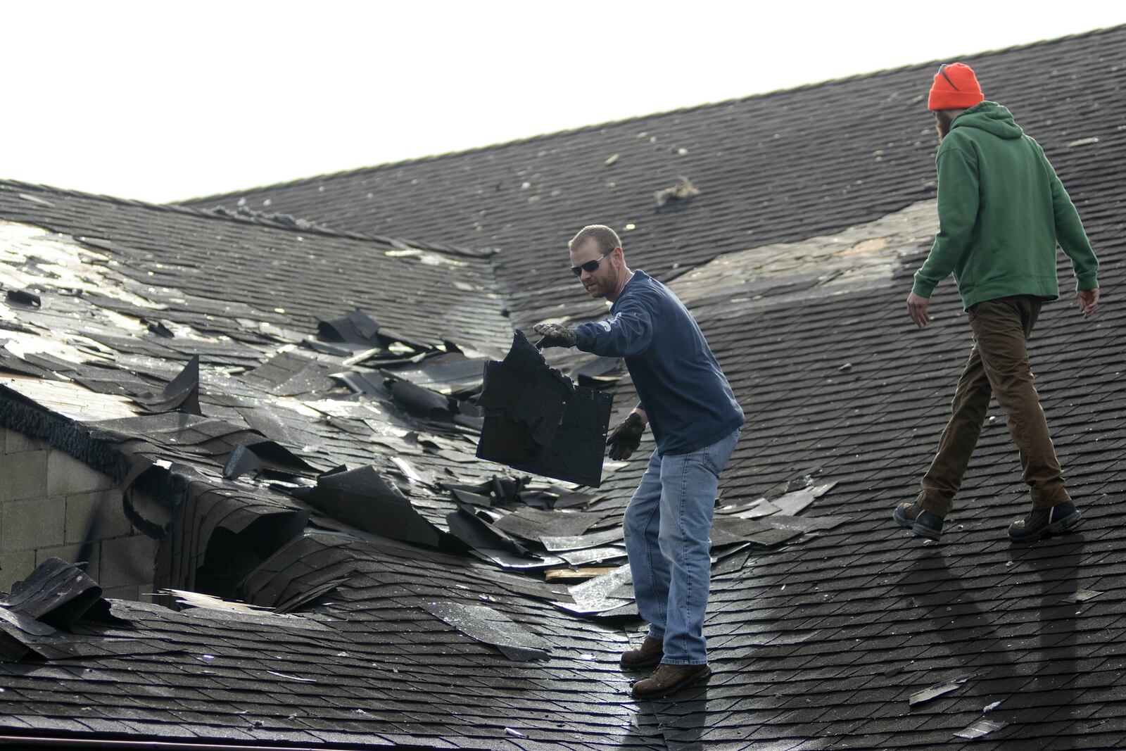 Fire ravaged a large part of the Tytus Avenue First Church of God in Middletown in the early hours Sunday morning. A cause for the fire has yet to be determined. Middletown Division of Fire Deputy Fire Chief Brent Dominy said investigators will resume work on Monday. Pictured are members of a cleanup crew discarding damaged shingles off the roof. MICHAEL D. PITMAN/STAFF