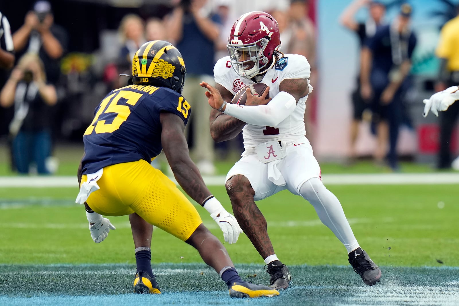 Alabama quarterback Jalen Milroe (4) cuts in front of Michigan linebacker Ernest Hausmann during the first half of the ReliaQuest Bowl NCAA college football game Tuesday, Dec. 31, 2024, in Tampa, Fla. (AP Photo/Chris O'Meara)