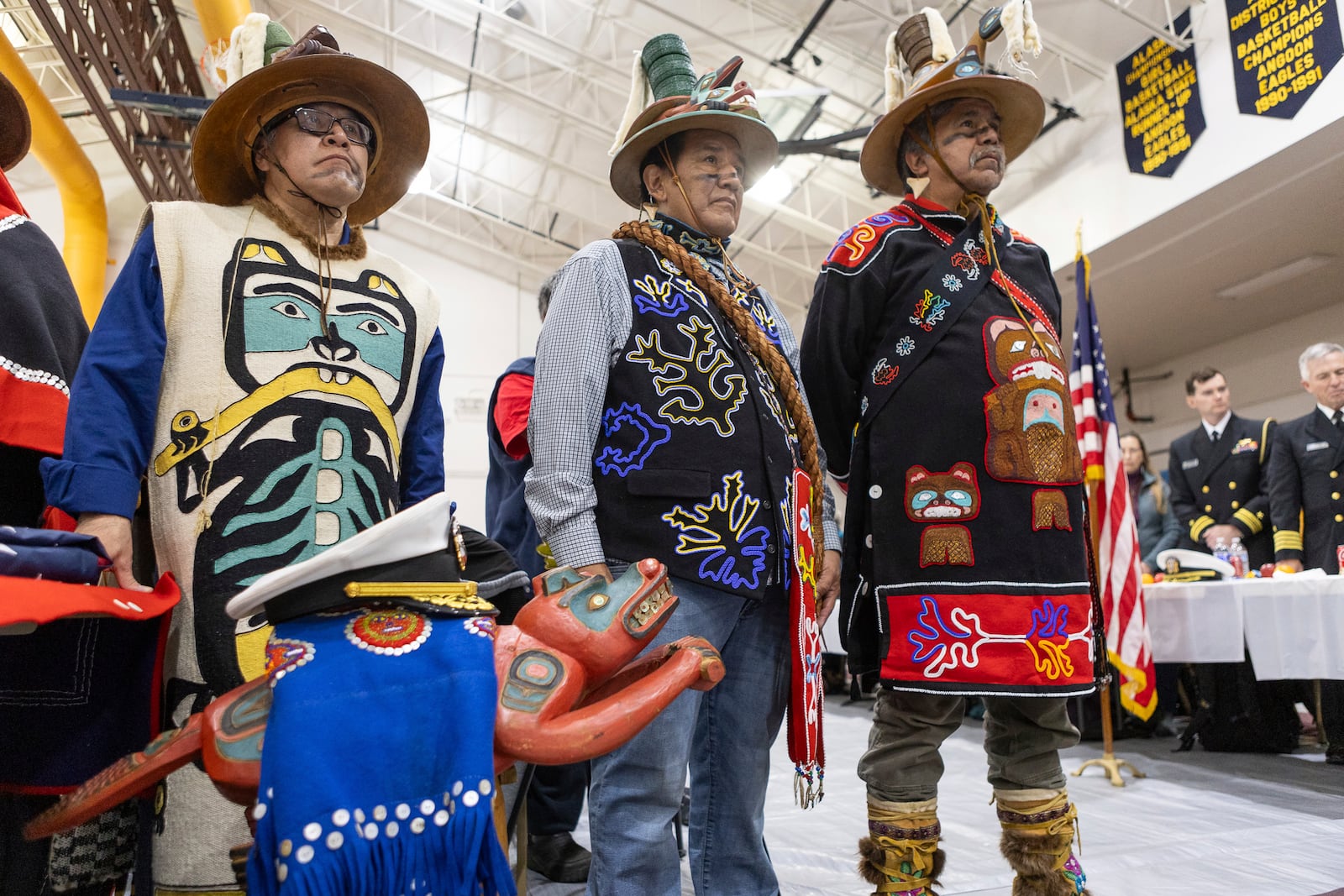 Angoon residents with a beaver prow, which survived the Angoon bombing by the U.S. Navy, listen during a ceremony Saturday, Oct. 26, 2024, in Angoon, Alaska, where the Navy apologized for the 1882 military bombing on a Tlingit village in Angoon. (Nobu Koch/Sealaska Heritage Institute via AP)