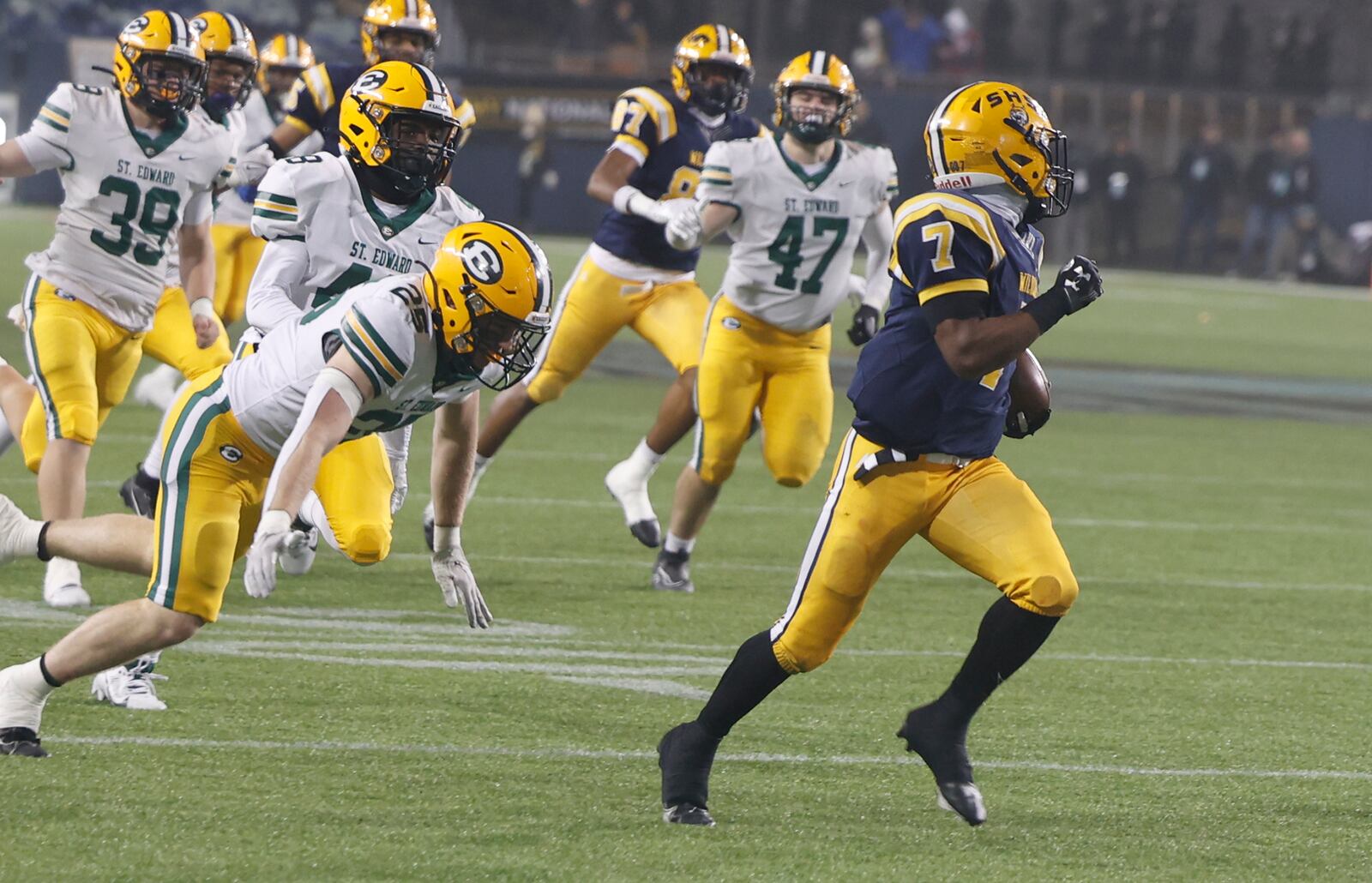 Springfield's Jayvin Norman is chased by a pack of St. Edward defenders Friday, Dec. 1, 2023 as he carries a kickoff return back for a touchdown, setting a Division I state record in the process. BILL LACKEY/STAFF