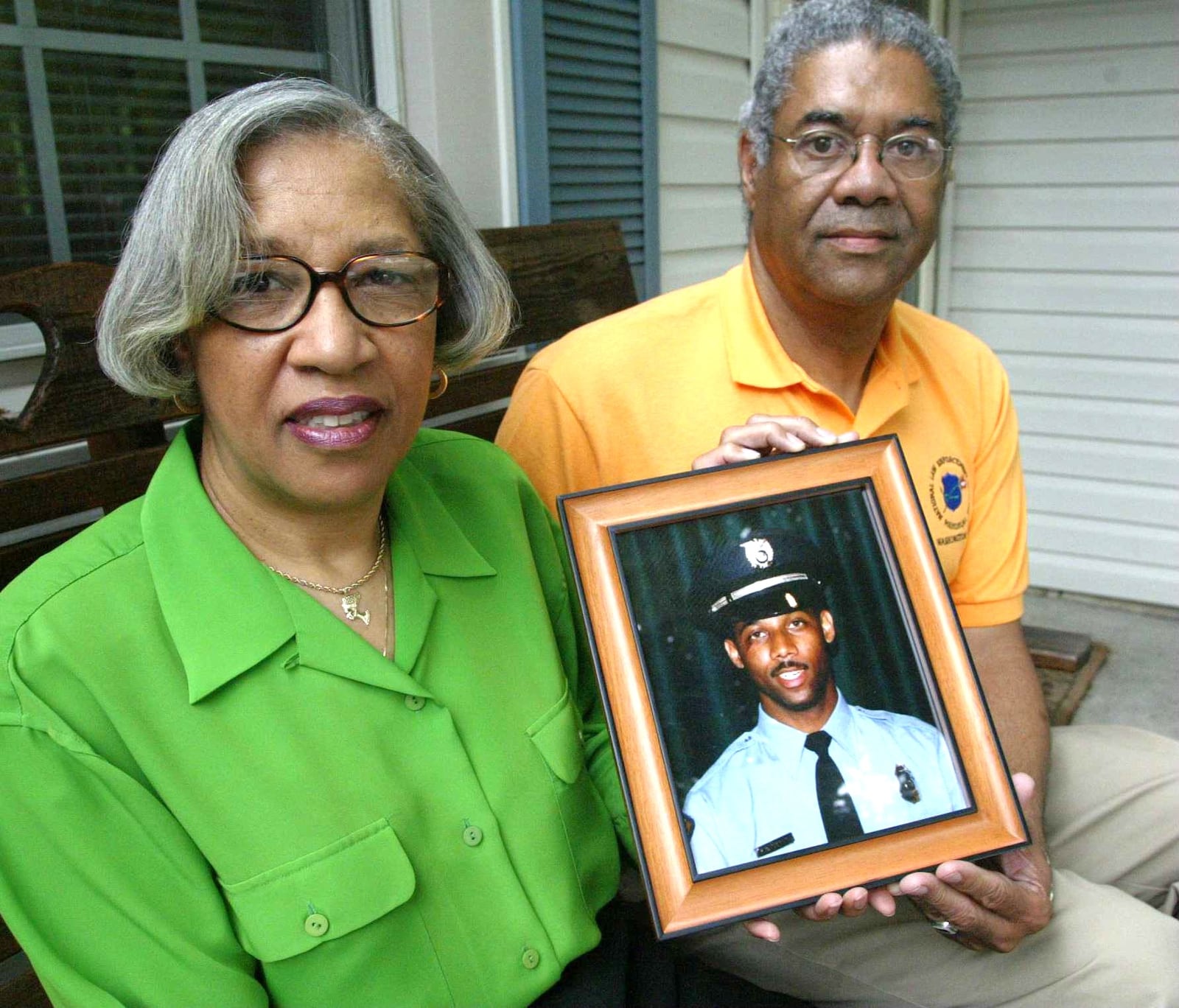 Rosemary Brame and Gerald Brame, hold a picture of their son, Kevin Brame, a slain police officer. Kevin was killed on 1 November 1999 and the police have yet to catch the killer.