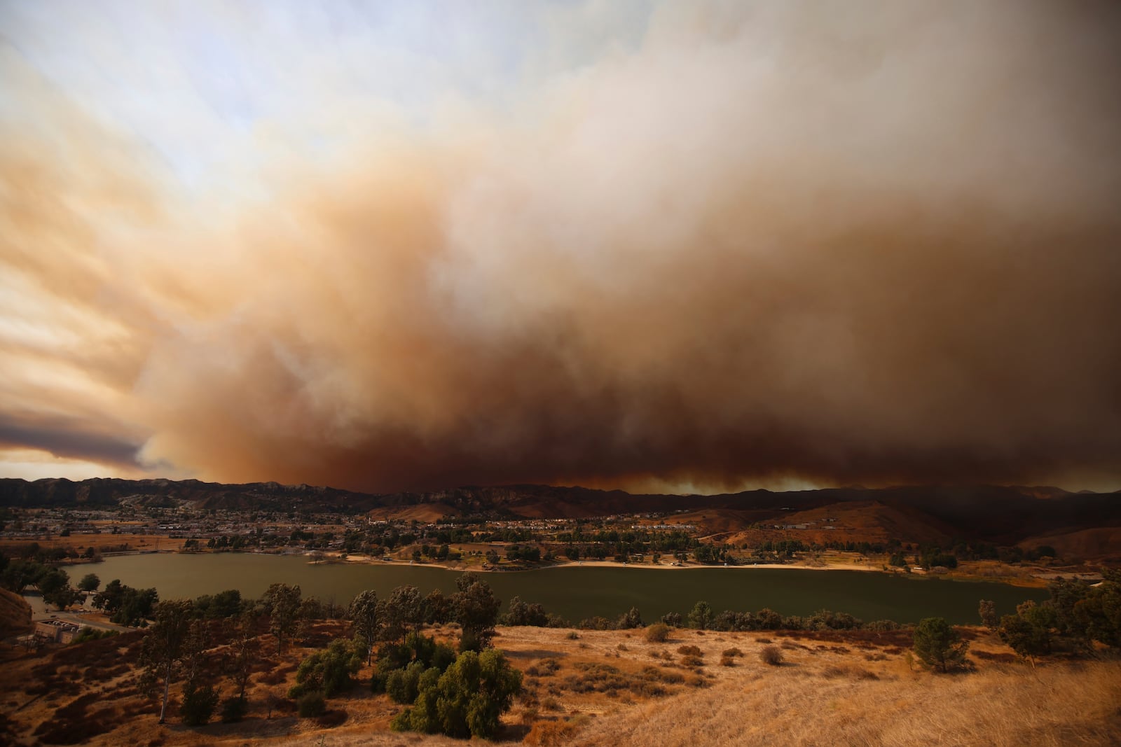 FILE - Plumes of smoke caused by the Hughes Fire rise over Castaic, Calif., Jan. 22, 2025. (AP Photo/Ethan Swope, File)