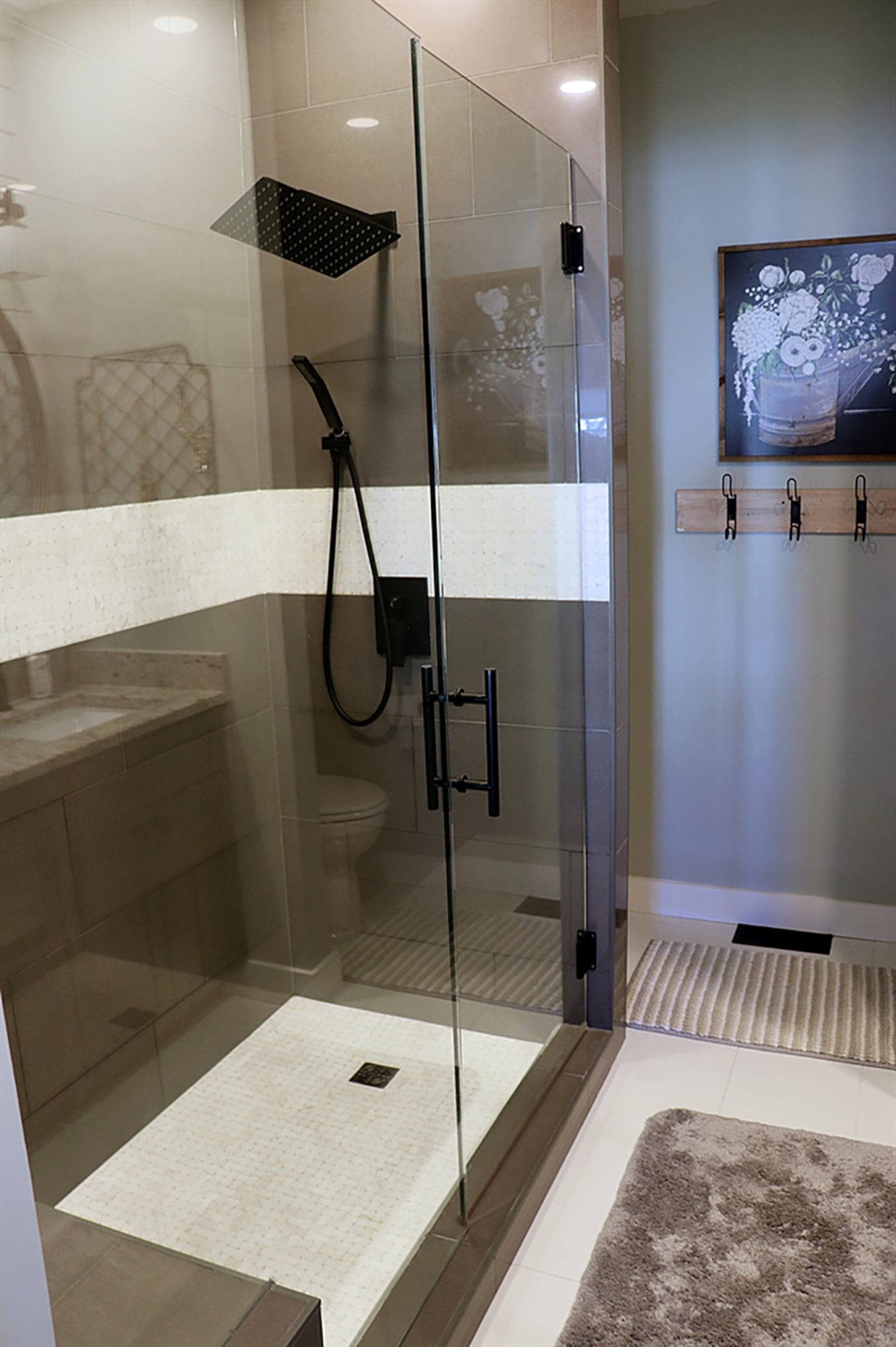 Behind a sliding barn-door, the main bedroom suite’s bath has a walk-in, ceramic-tile shower with seat and glass doors. CONTRIBUTED PHOTO BY KATHY TYLER