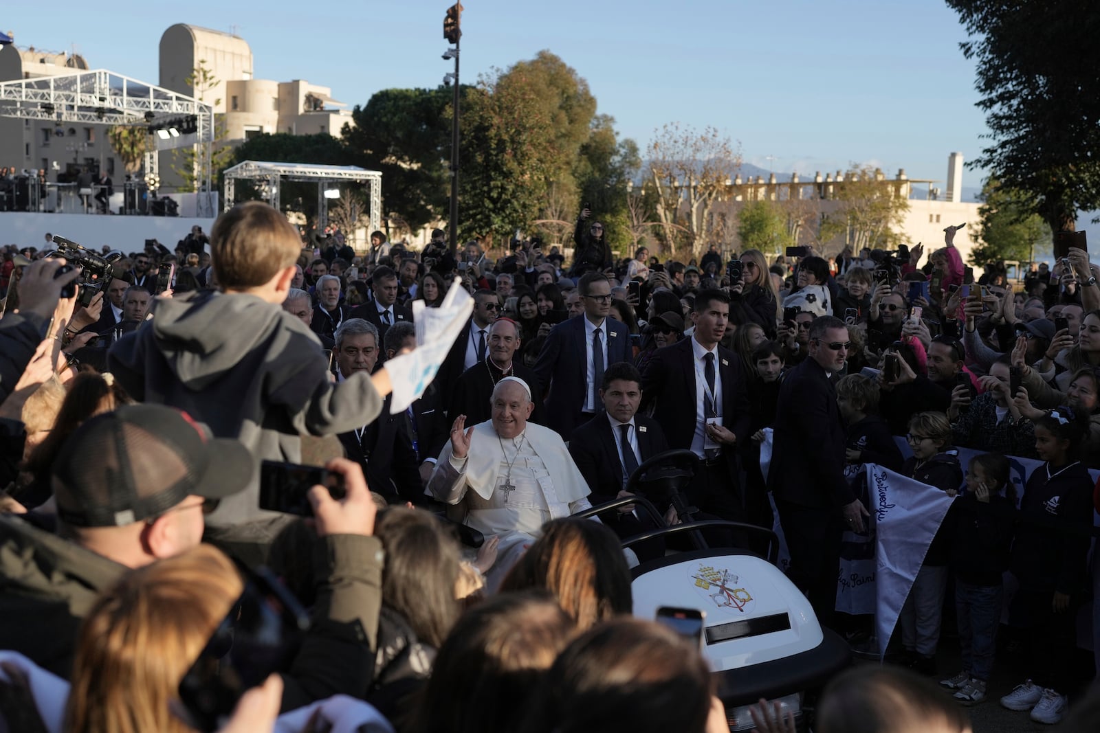 Pope Francis arrives for a mass Sunday, Dec. 15, 2024 in Ajaccio, Corsica island, as his one-day visit to Corsica puts a dual focus on the Mediterranean, highlighting local traditions of popular piety on the one hand and migrant deaths and wars on the other. (AP Photo/Thibault Camus)