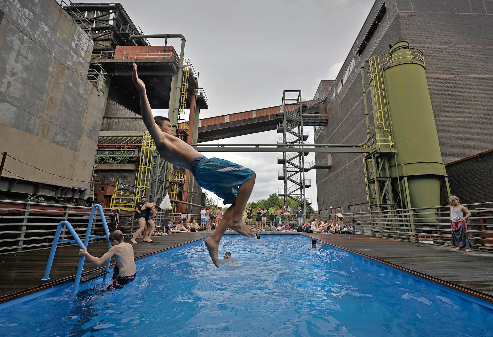 FILE - Children jump into a factory pool on a hot summer day at the former coking plant Zollverein in Essen, Germany, Tuesday, Aug. 6, 2013. (AP Photo/Martin Meissner, File)