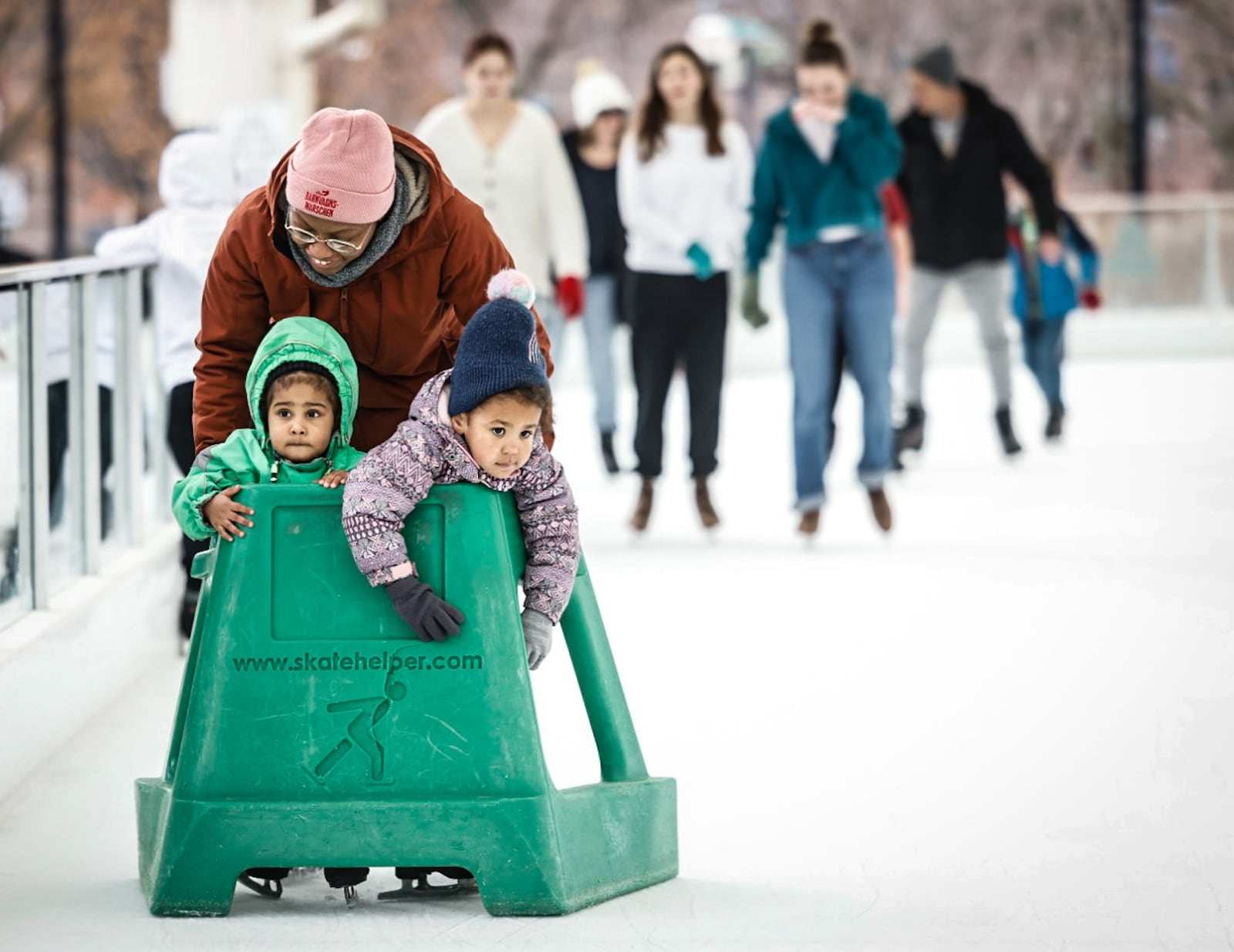 Hope Jeter pushes Fatima Jeter and Avery Gharst on a warm winter day at Five Rivers MetroPark ice rink at RiverScape Thursday December 26, 2024. Warm weather will continue into next week. JIM NOELKER/STAFF