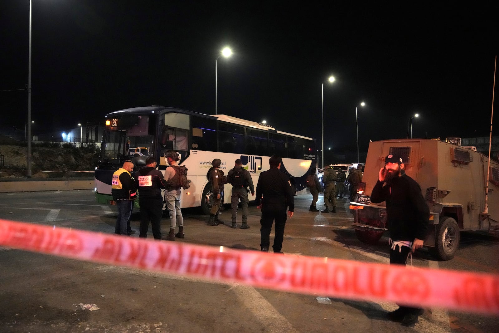 Israeli security forces work at the scene of a shooting attack on a bus near the West Bank town of Beit Jala, early Thursday, Dec. 12, 2024. (AP Photo/Mahmoud Illean)