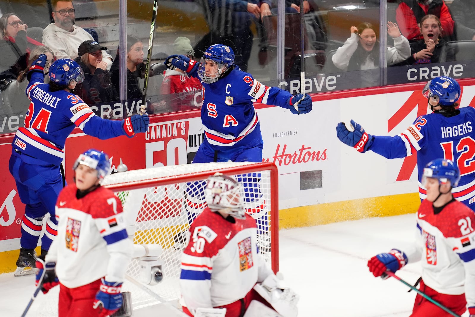 United States forward Ryan Leonard (9) celebrates after his goal with teammates Gabe Perreault (34) and James Hagens (12) during third-period World Junior hockey championship semifinal game action against Czechia in Ottawa, Ontario, Saturday, Jan. 4, 2025. (Sean Kilpatrick/The Canadian Press via AP)