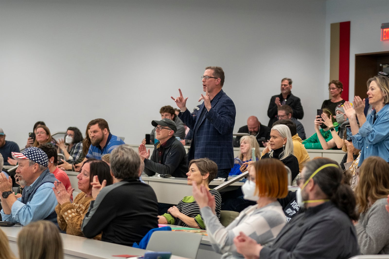 Participants stand up to ask questions over the noise of the crowd during a GOP town hall meeting with Reps. Mike Kennedy and Celeste Maloy, R-Utah, Thursday, March 20, 2025, in Salt Lake City. (AP Photo/Rick Egan)