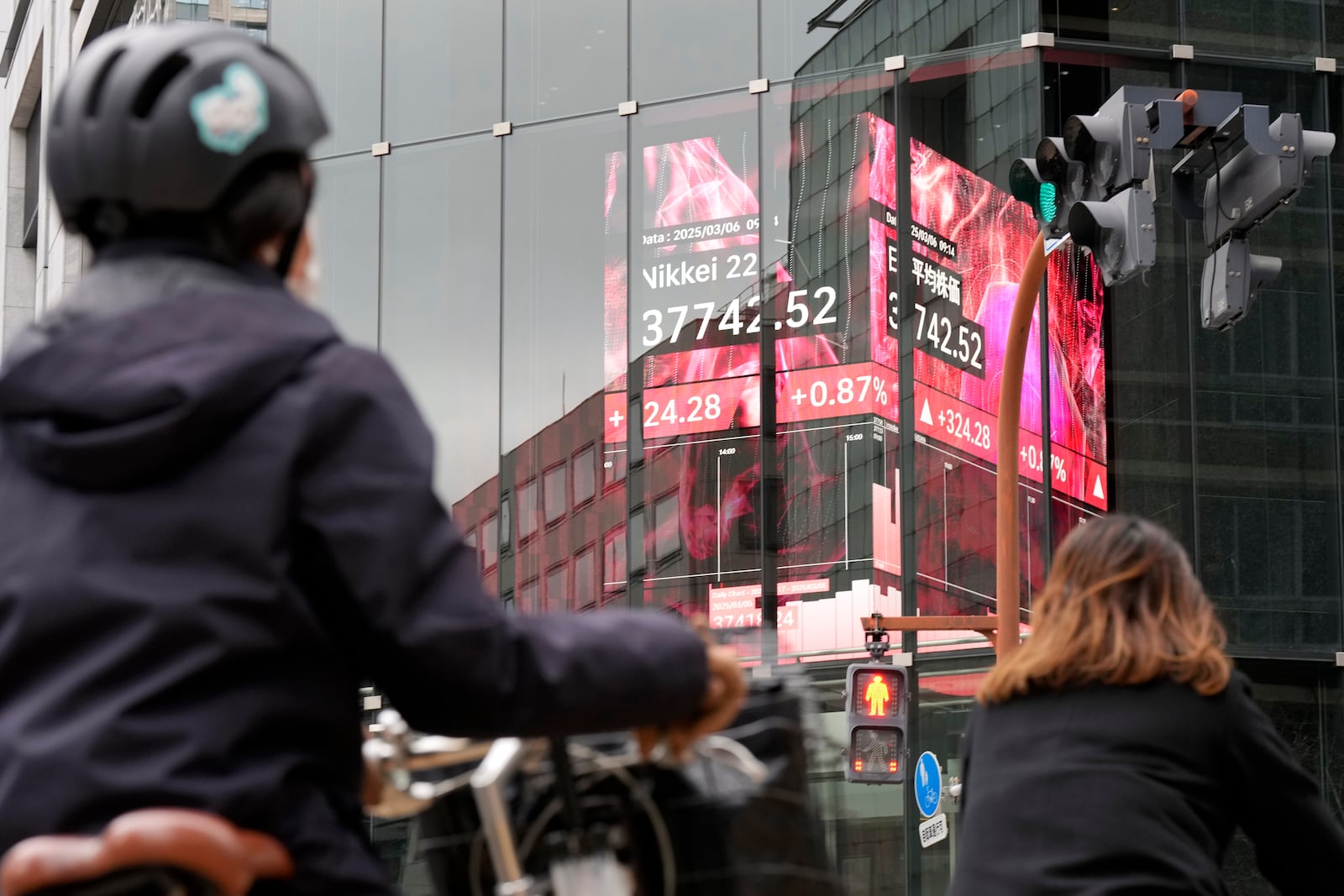 People stand in front of an electronic stock board showing Japan's Nikkei index at a securities firm Thursday, March 6, 2025, in Tokyo. (AP Photo/Eugene Hoshiko)